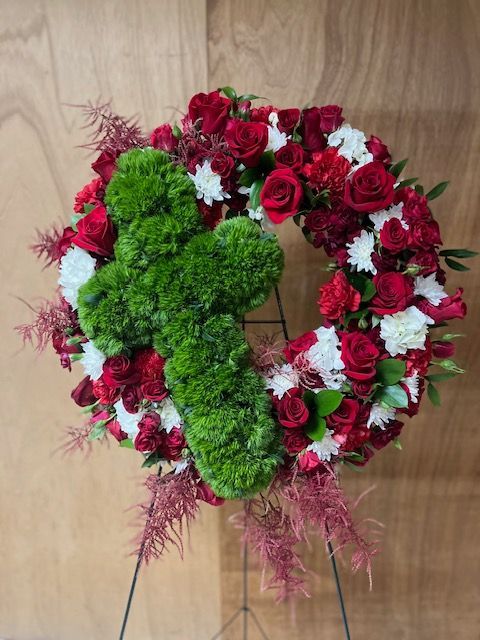 A wreath with a green cross in the middle of it