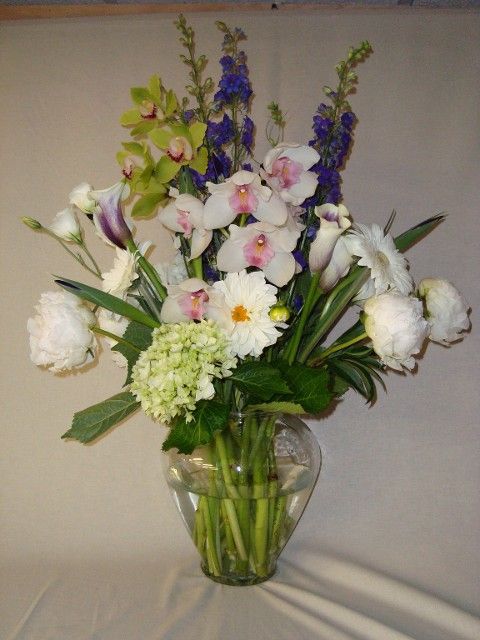 A vase filled with white flowers and purple flowers