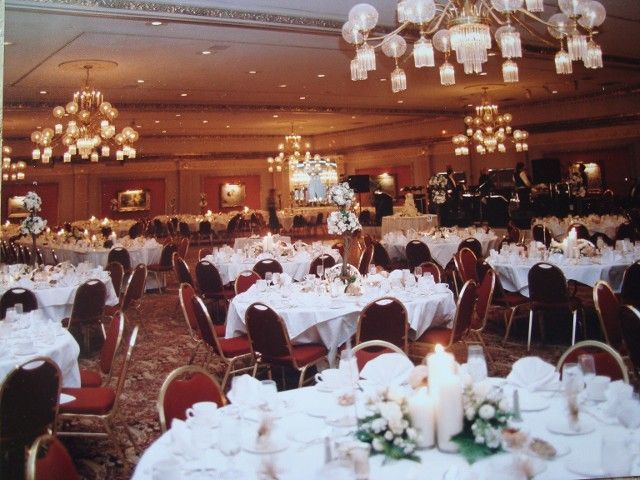 A large room with tables and chairs set up for a wedding reception