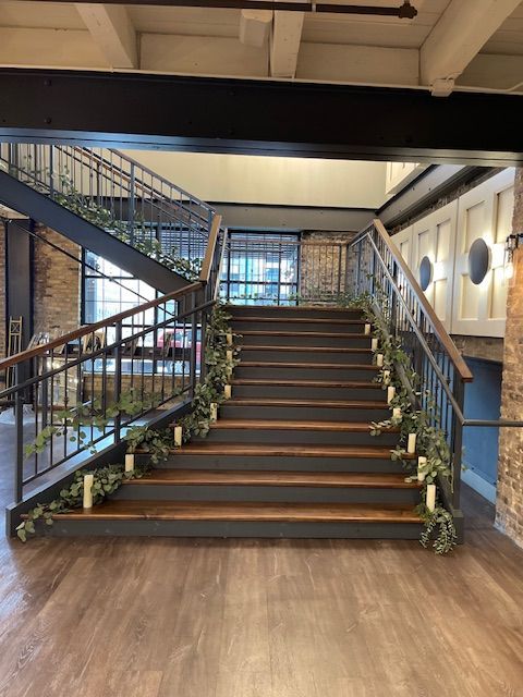 The stairs are decorated with candles and greenery
