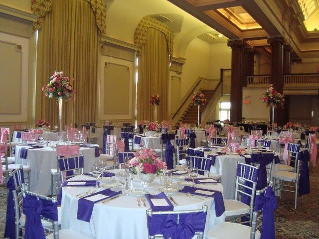 A large room with tables and chairs set up for a wedding reception