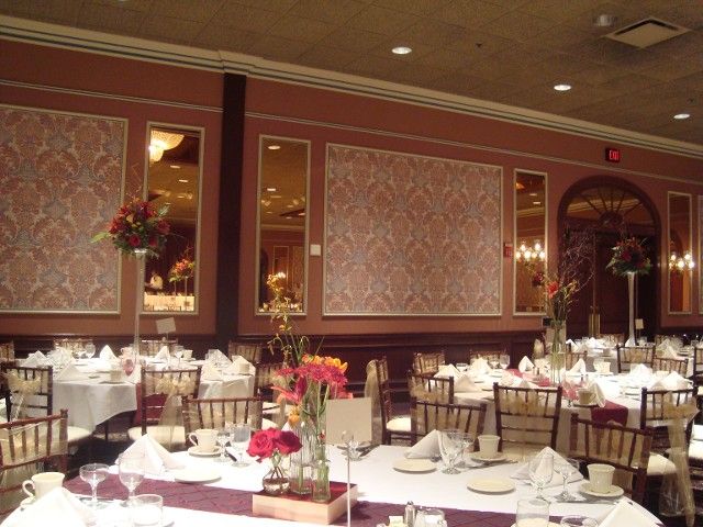 A large room with tables and chairs set up for a wedding reception