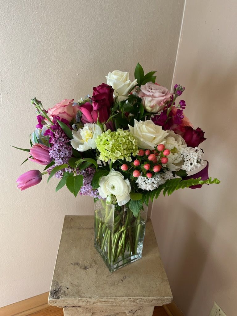 A silver vase filled with pink and yellow flowers
