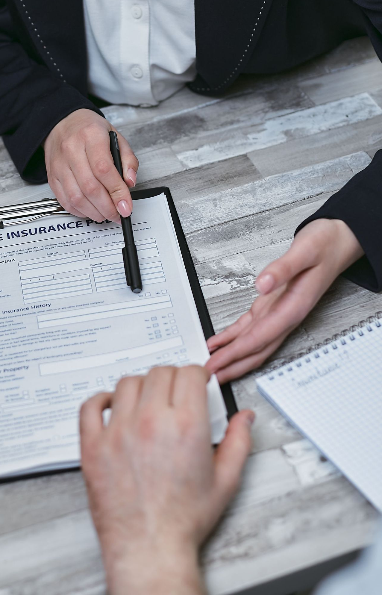 Handing over house keys beside a calculator, contract, and laptop during a real estate sale