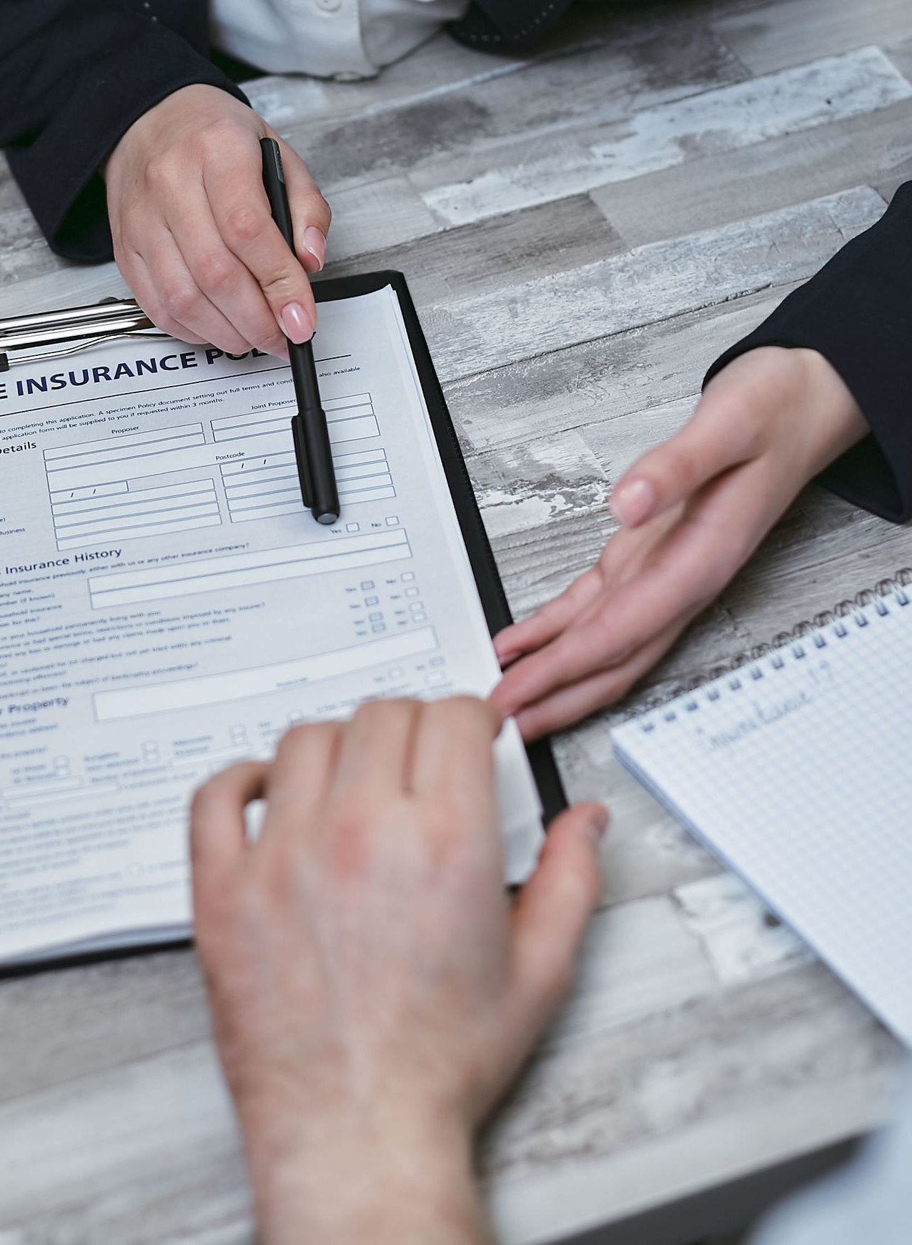 Handing over house keys beside a calculator, contract, and laptop during a real estate sale