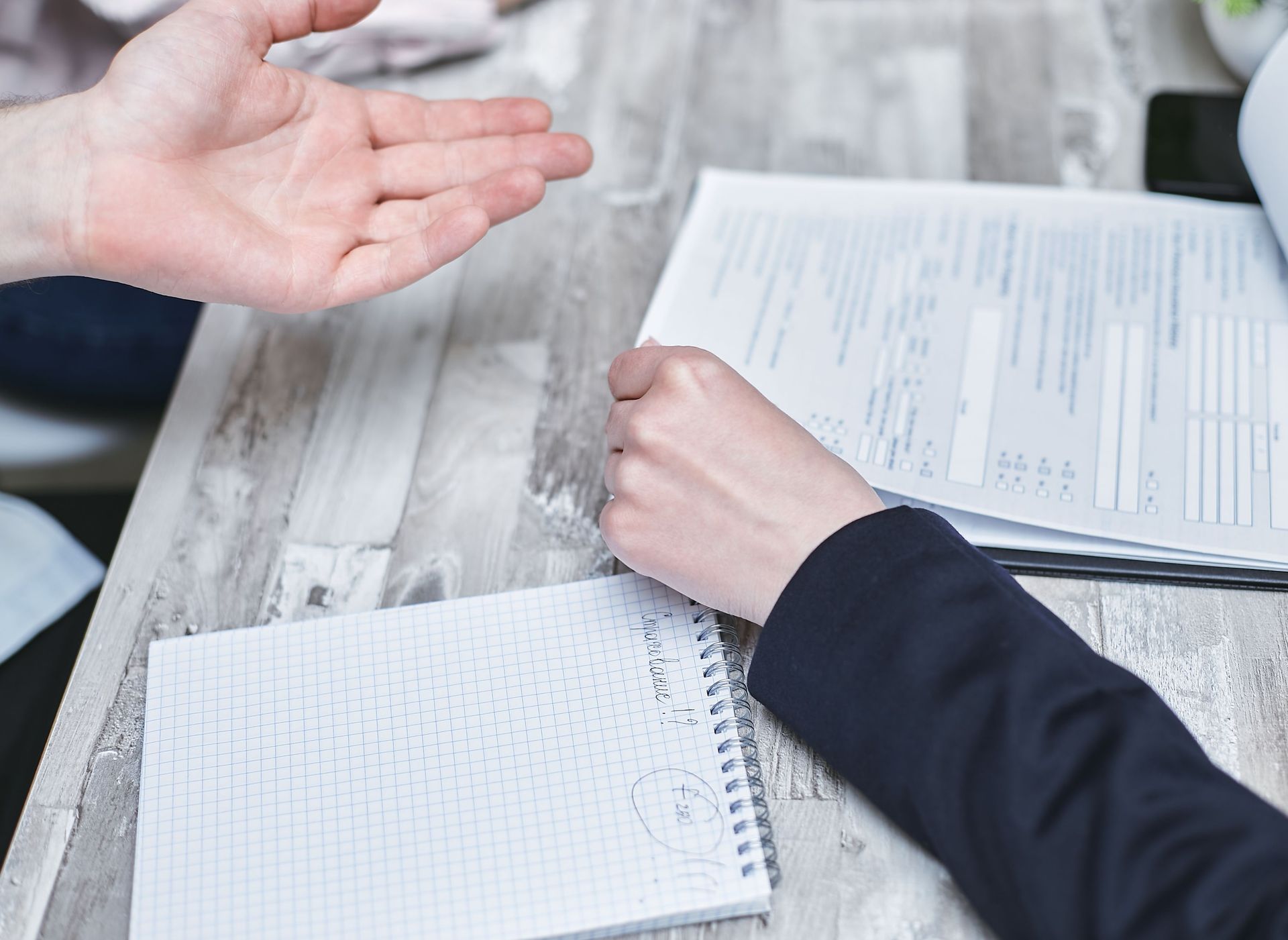 Handing over house keys beside a calculator, contract, and laptop during a real estate sale