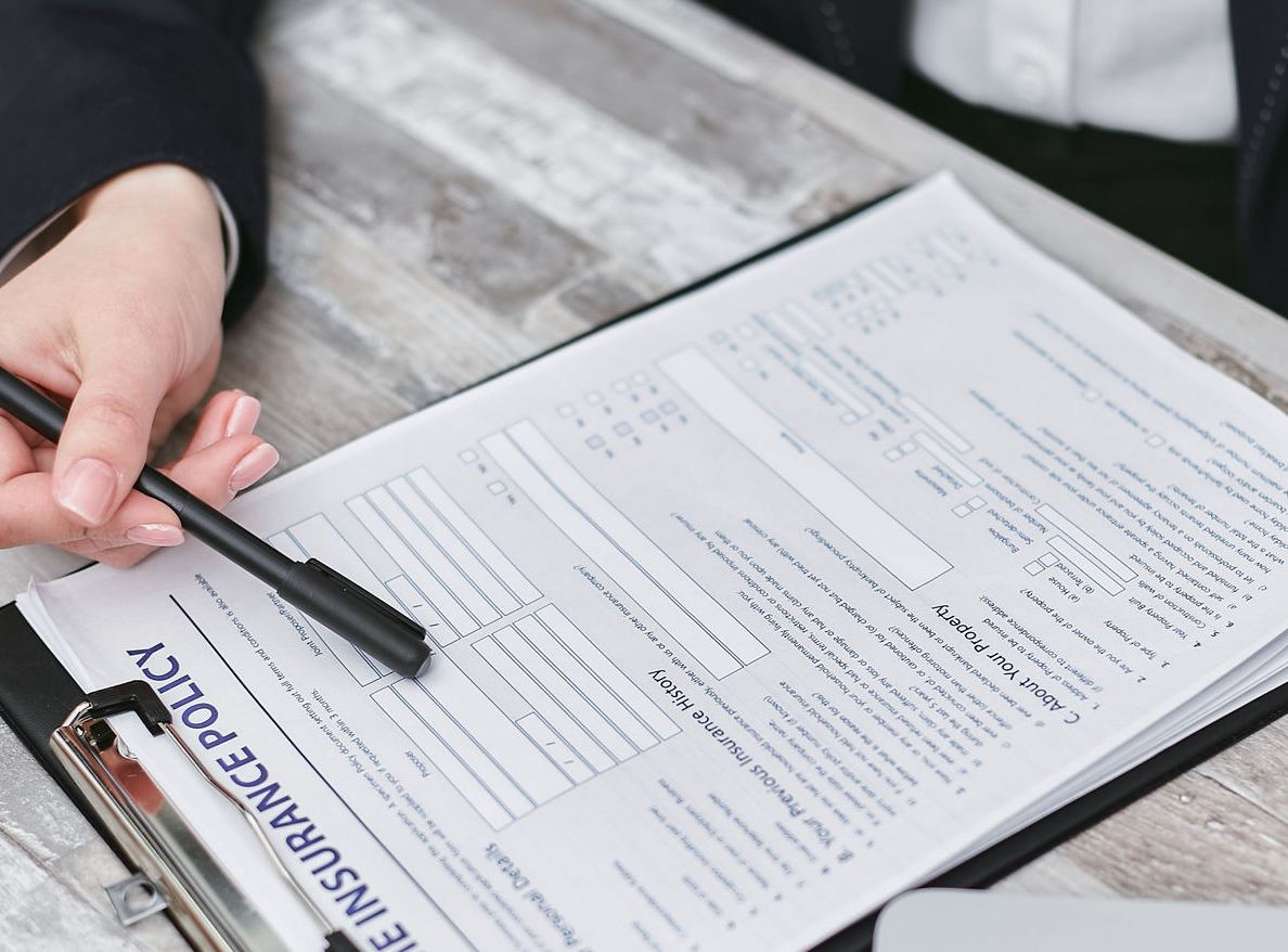 Hands signing documents at a desk with laptop and calculator in a business meeting collage