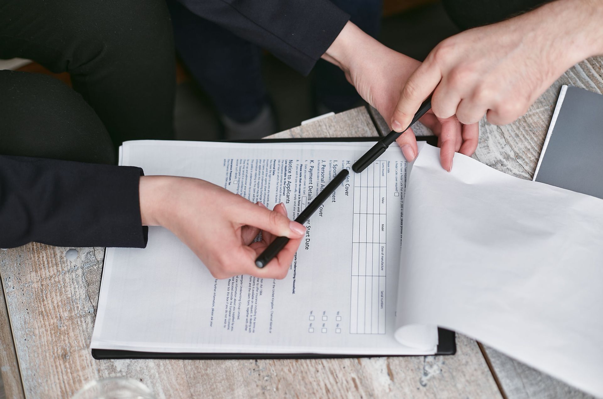 Handing over house keys beside a calculator, contract, and laptop during a real estate sale