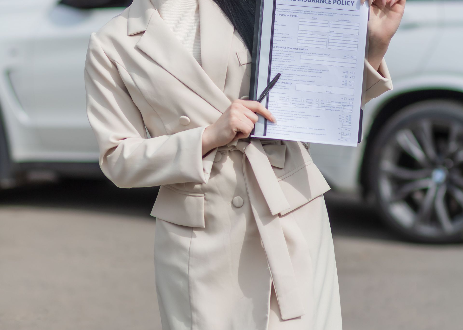 Business meeting with charts and hands using a laptop, plus an icon of people under an umbrella symbolizing insurance.