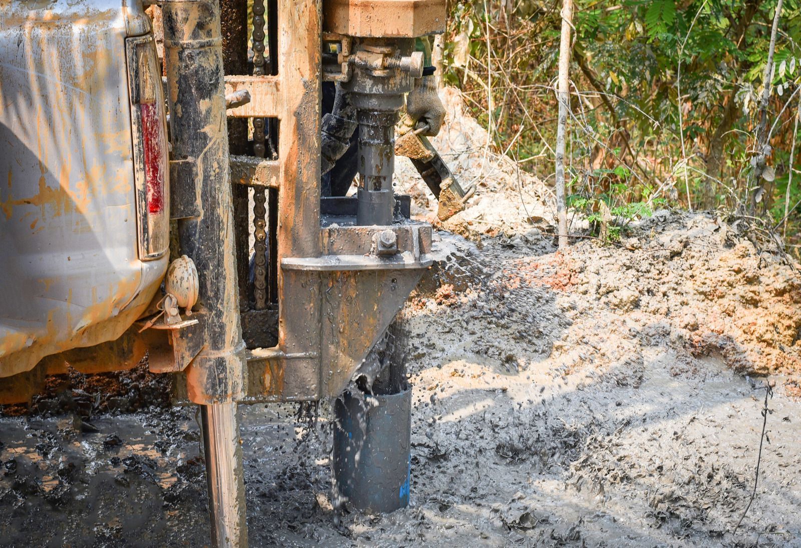 Drilling rig boring into muddy ground, close-up shot.