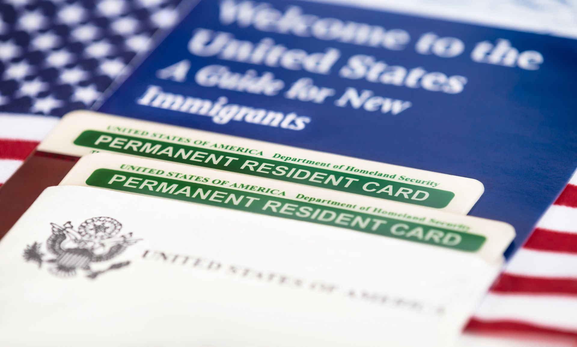 Green cards and guide for new immigrants on US flag.