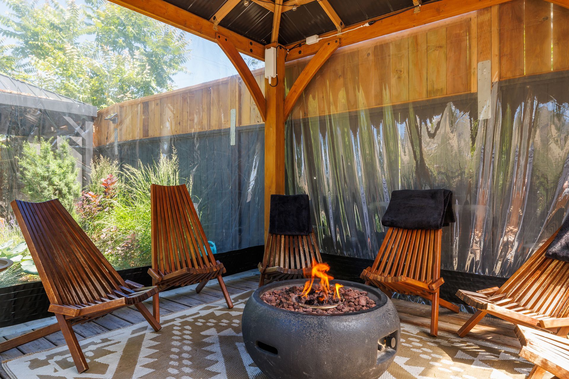 Two metal stock tanks filled with water in a dimly lit outdoor space with an illuminated wooden barrel sauna in the back.