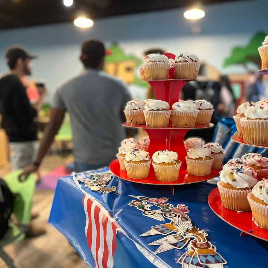 A display of cupcakes on a table with people in the background