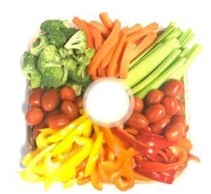 A tray of vegetables with a dipping sauce in the middle