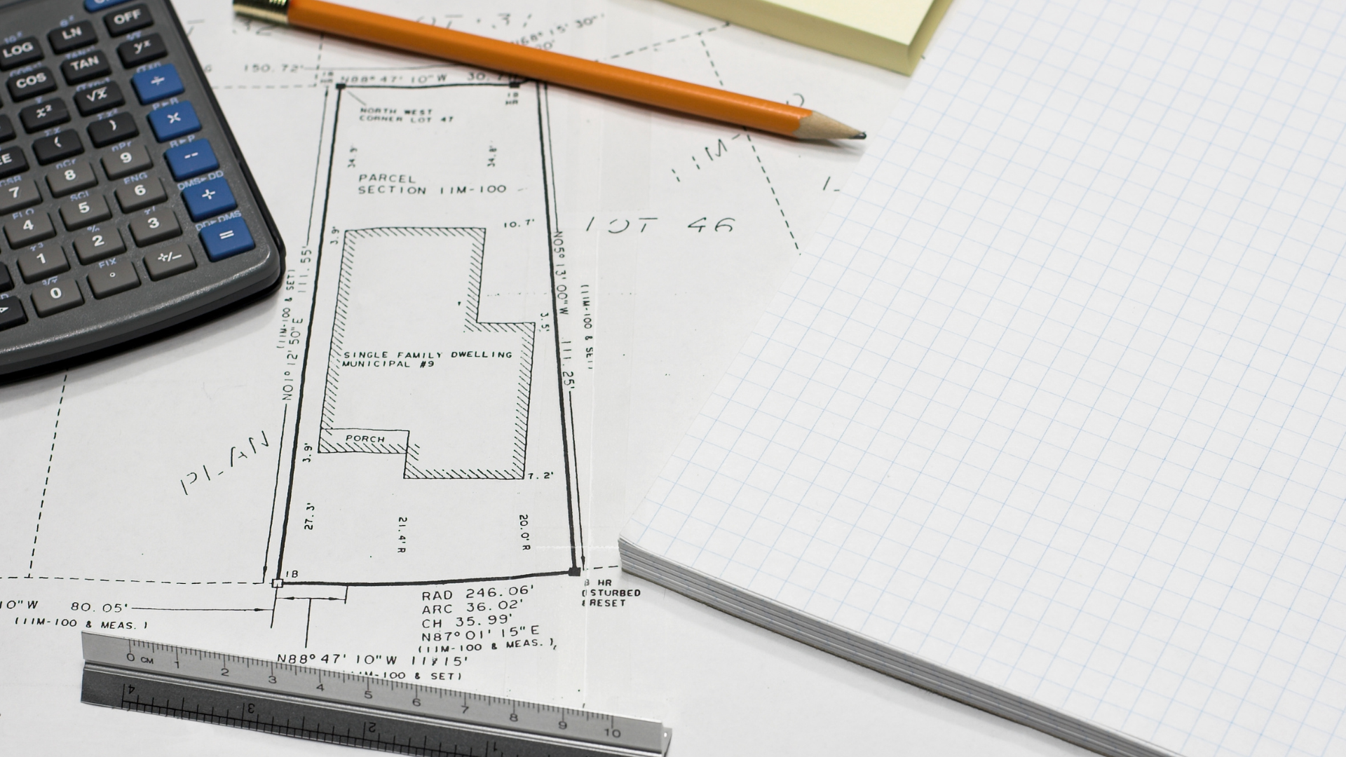 A calculator , pencil , ruler and sticky notes are on a piece of paper.