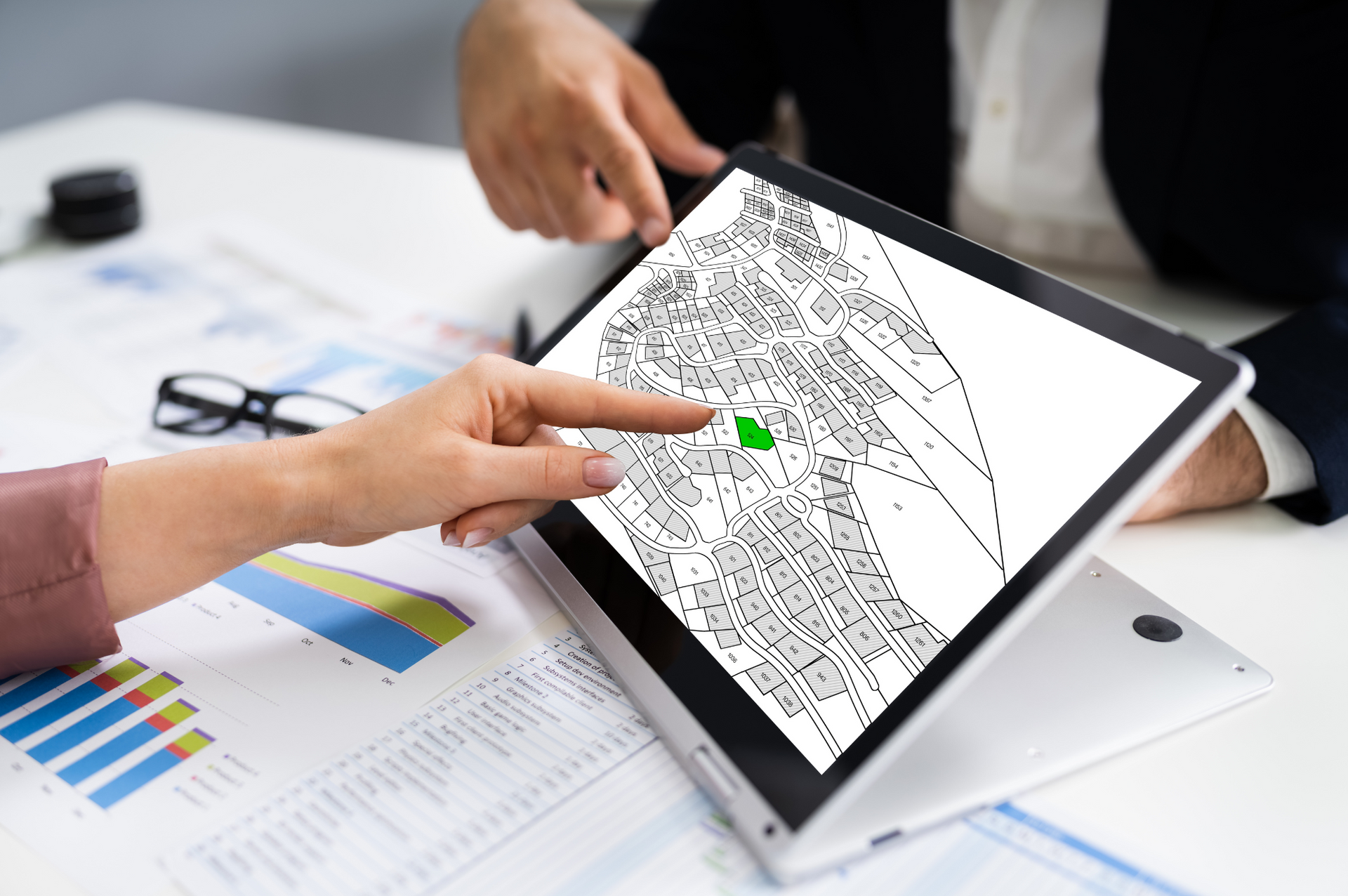 A man and a woman are looking at a map on a tablet.
