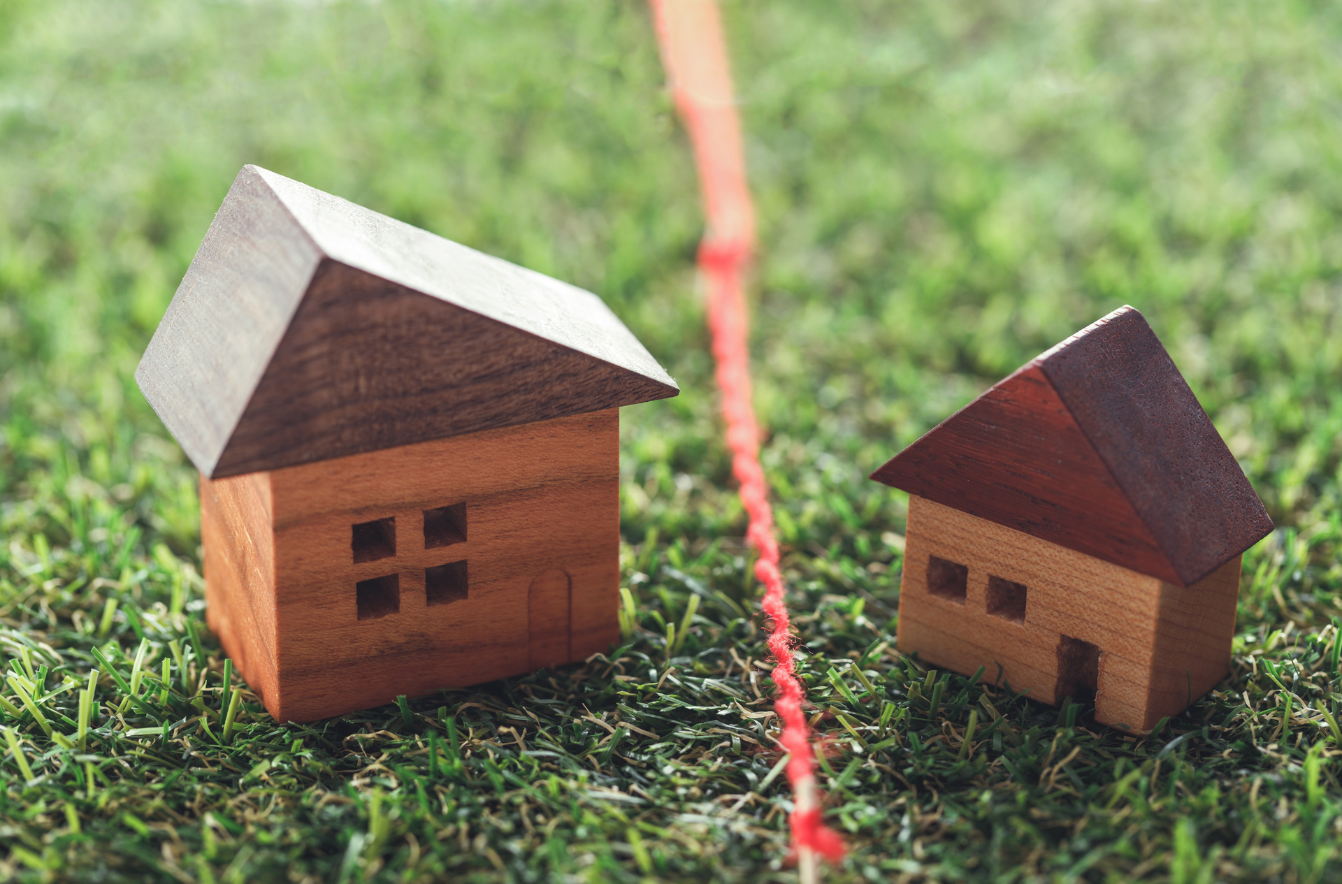 Two wooden houses are sitting next to each other on the grass.