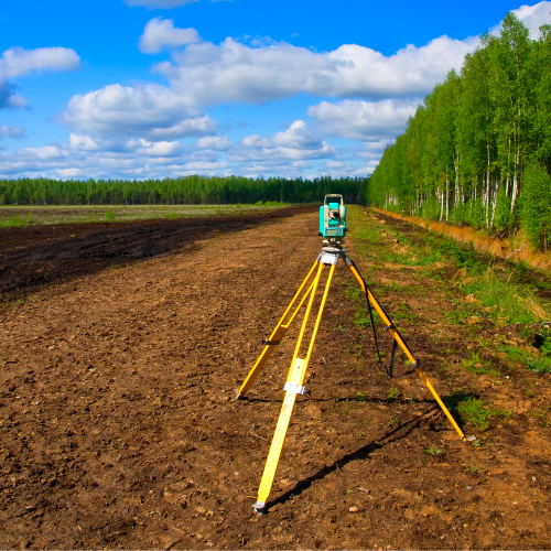 A tripod is sitting in the middle of a dirt field.