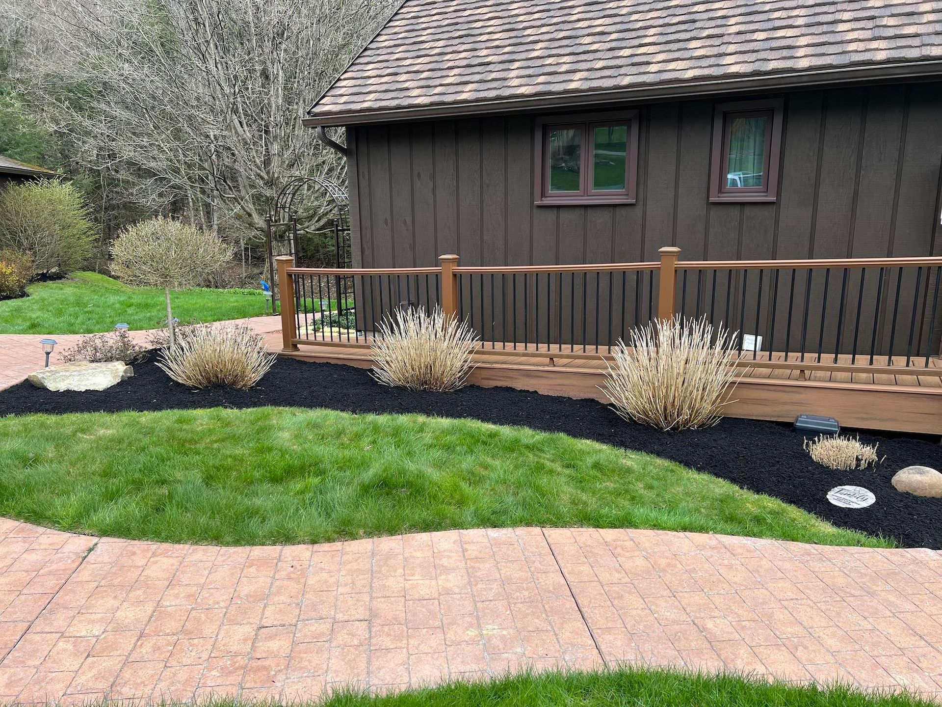 A house with a deck and a walkway in front of it.