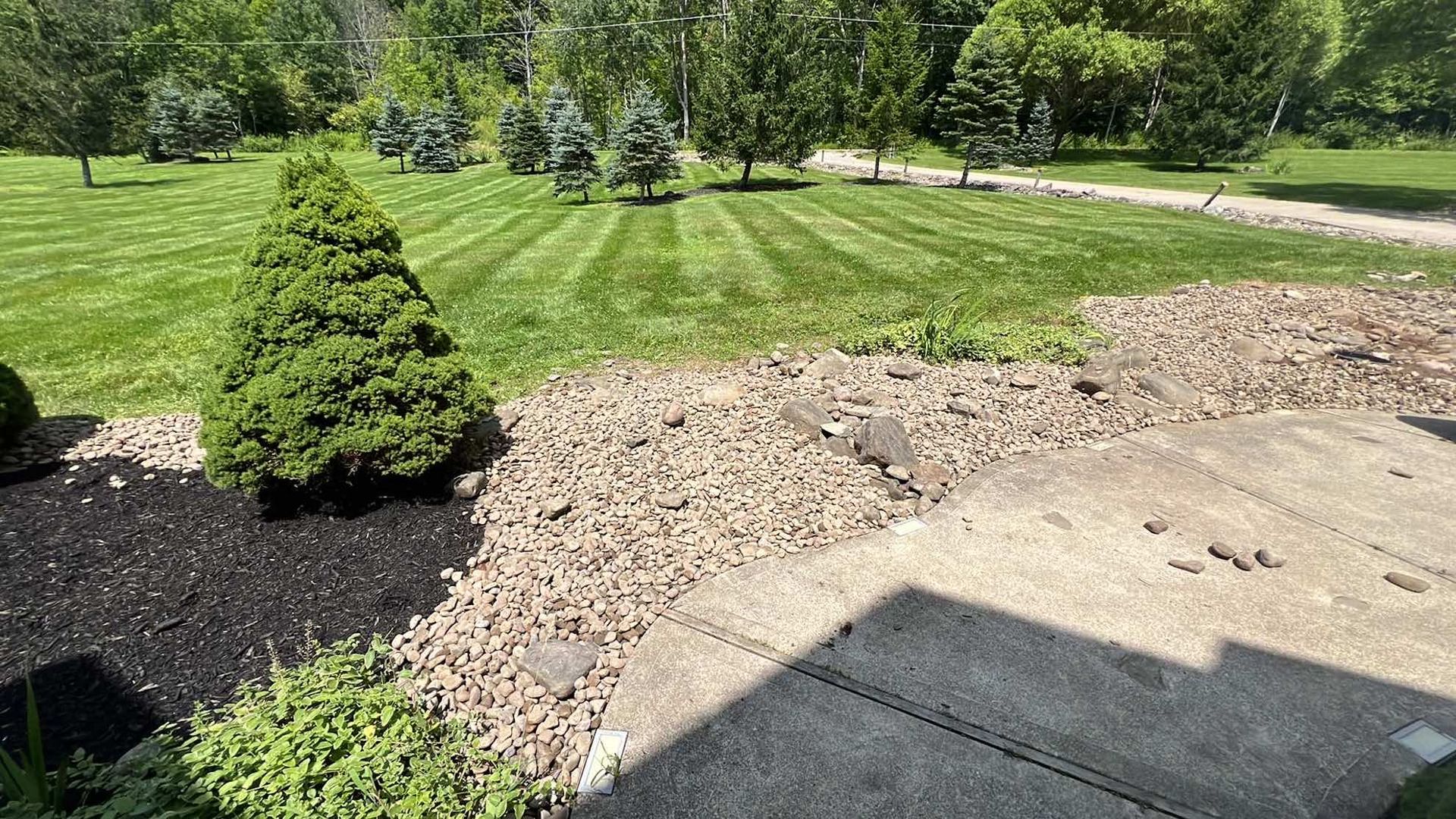 A view of a lush green lawn from a patio.