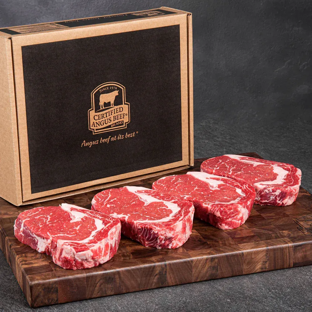 A box of certified angus beef sits on a wooden cutting board