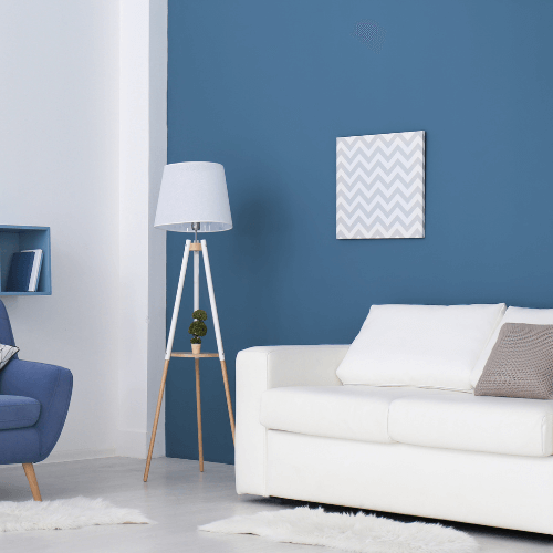 paint bucket, paint brush and paint swatches in a teal painted room