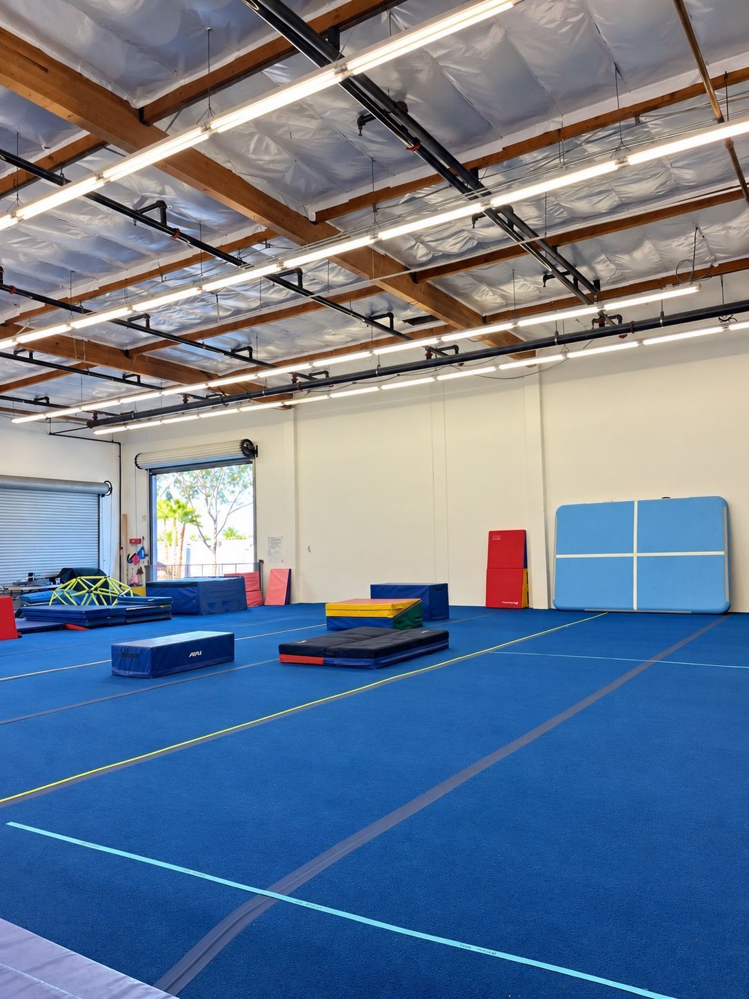 A first look at GRIT’s blue gymnastics floor and padded mats.