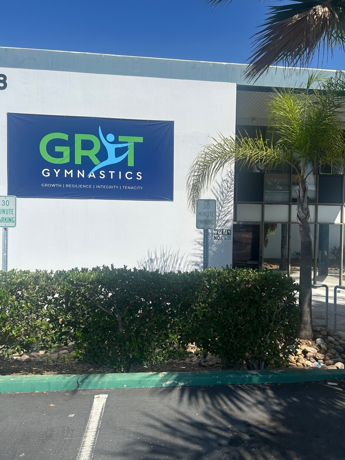 Gymnastics class gathered on the blue floor inside the GRIT gym.