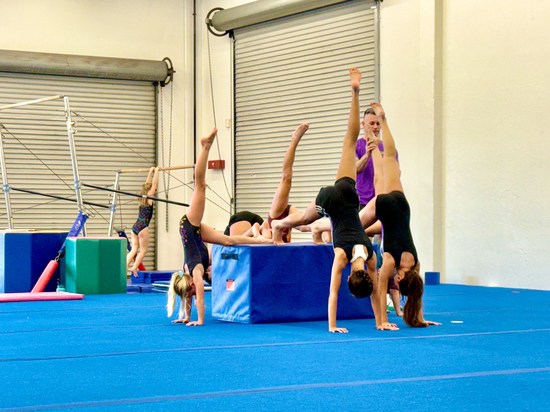 Woman stretching leg on a red mat in a gym, reaching for her toes.