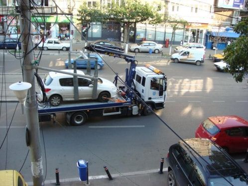 A tow truck is carrying a car on the back of it