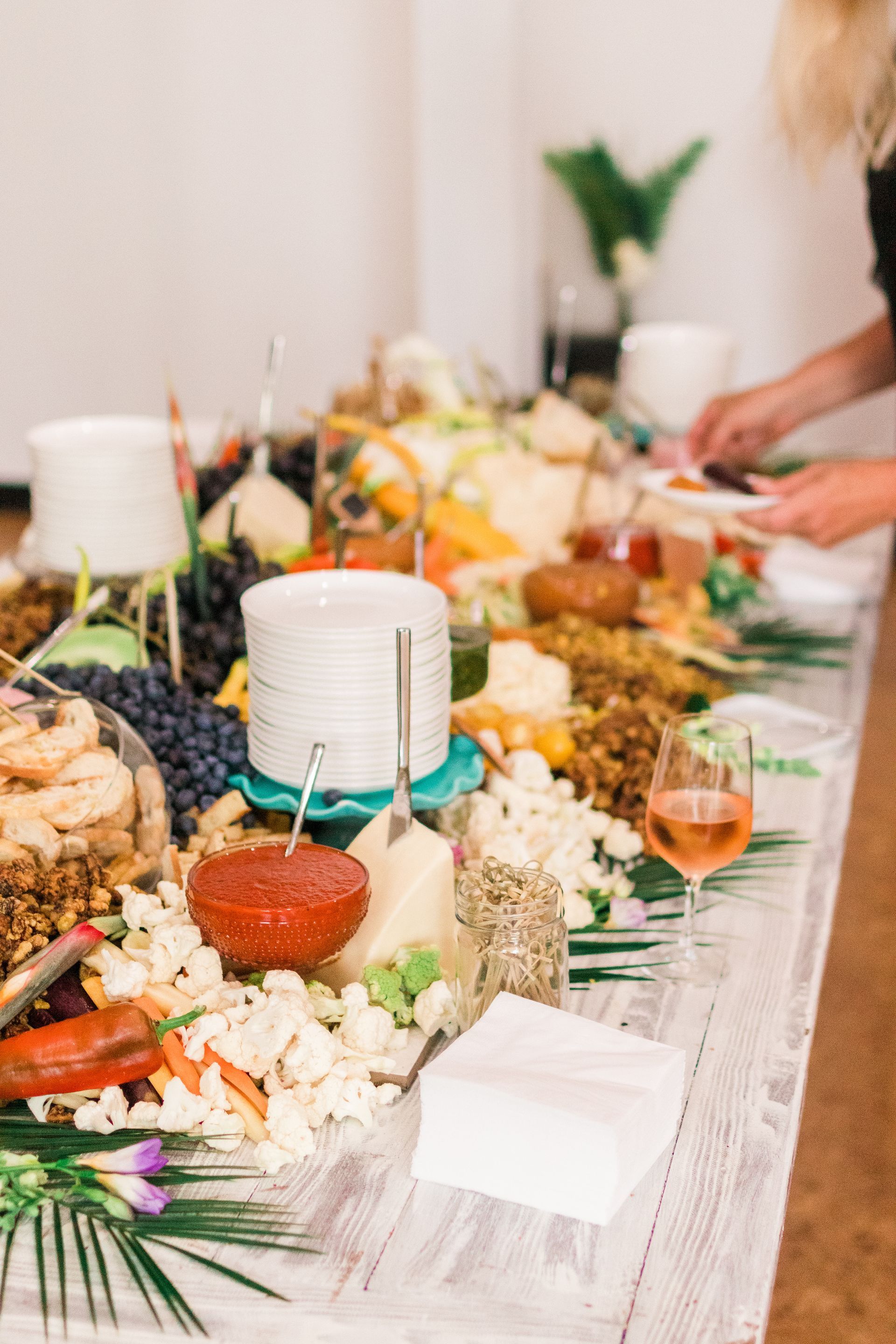 Decorated banquet table with candles, flowers, plates, and a person serving food at the far end