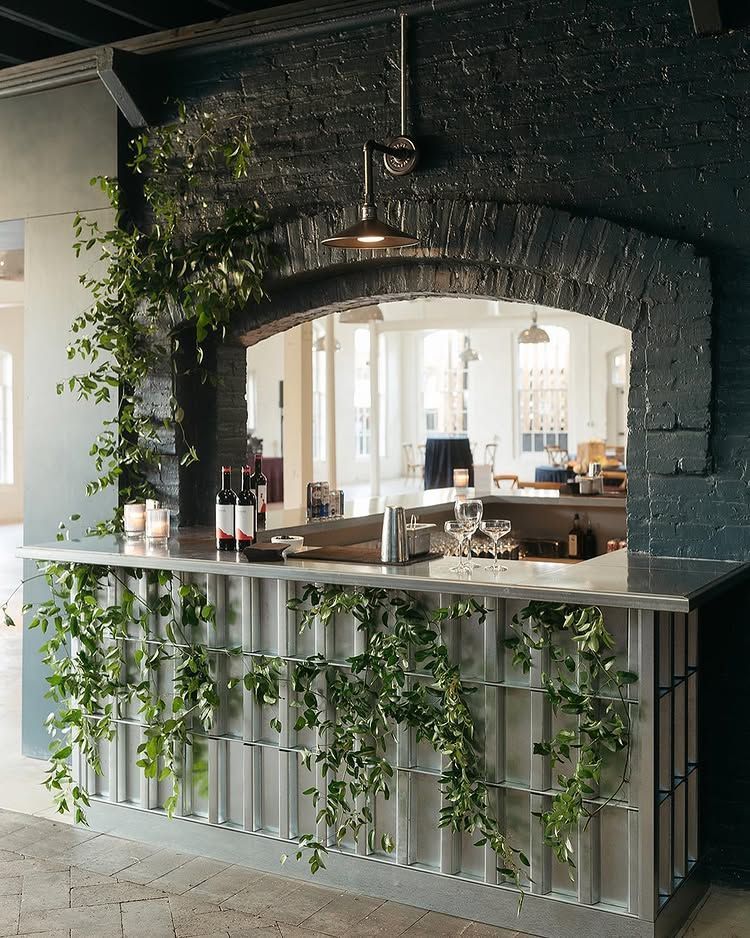 Rustic bar window with hanging greenery and pendant lights in a cozy restaurant interior