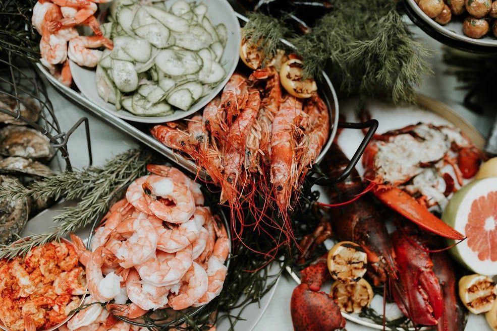 Seafood platter with shrimp, oysters, lemon slices, and herbs on a festive table