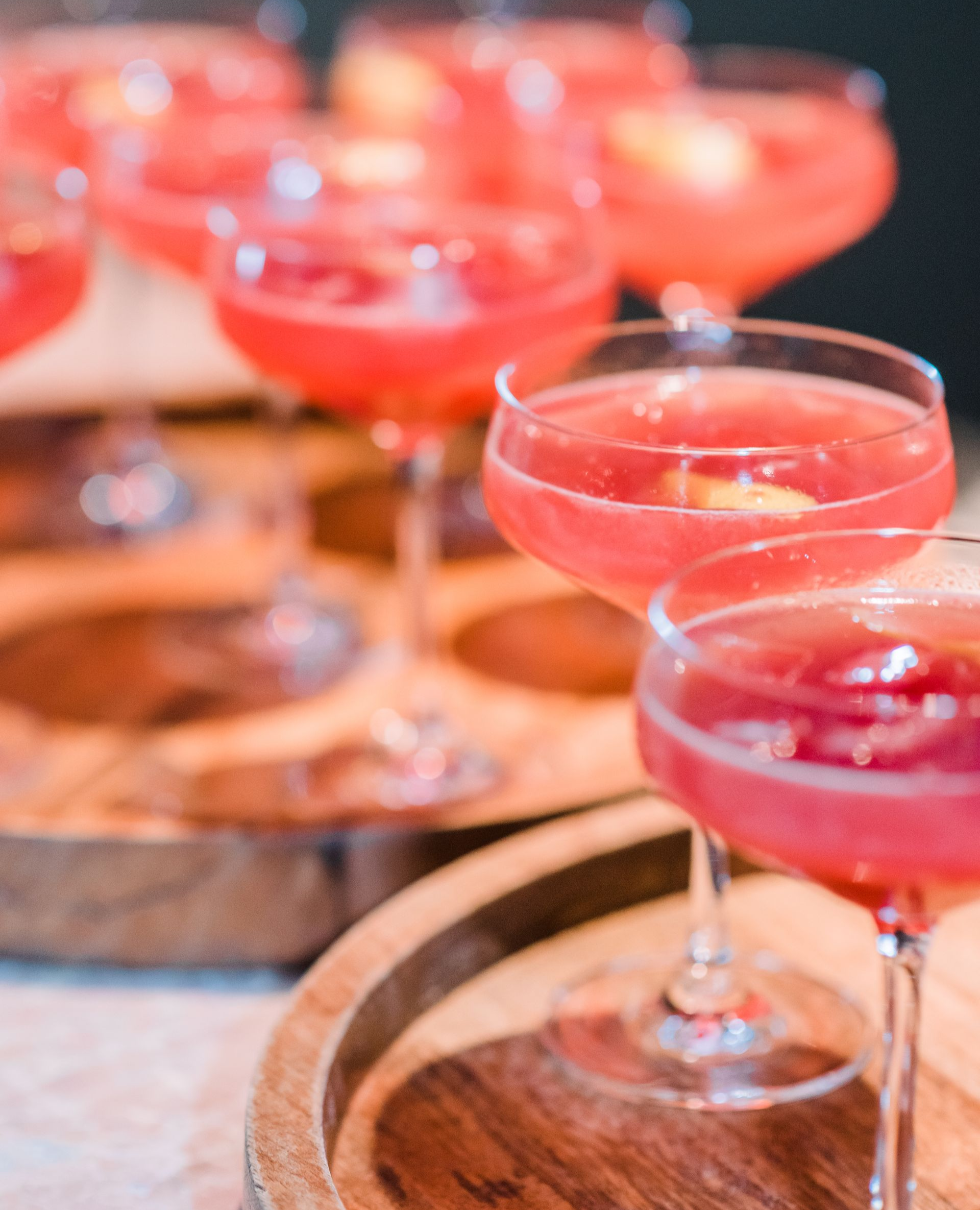 Cocktail party buffet table with appetizers and colorful drinks, guests mingling in the background