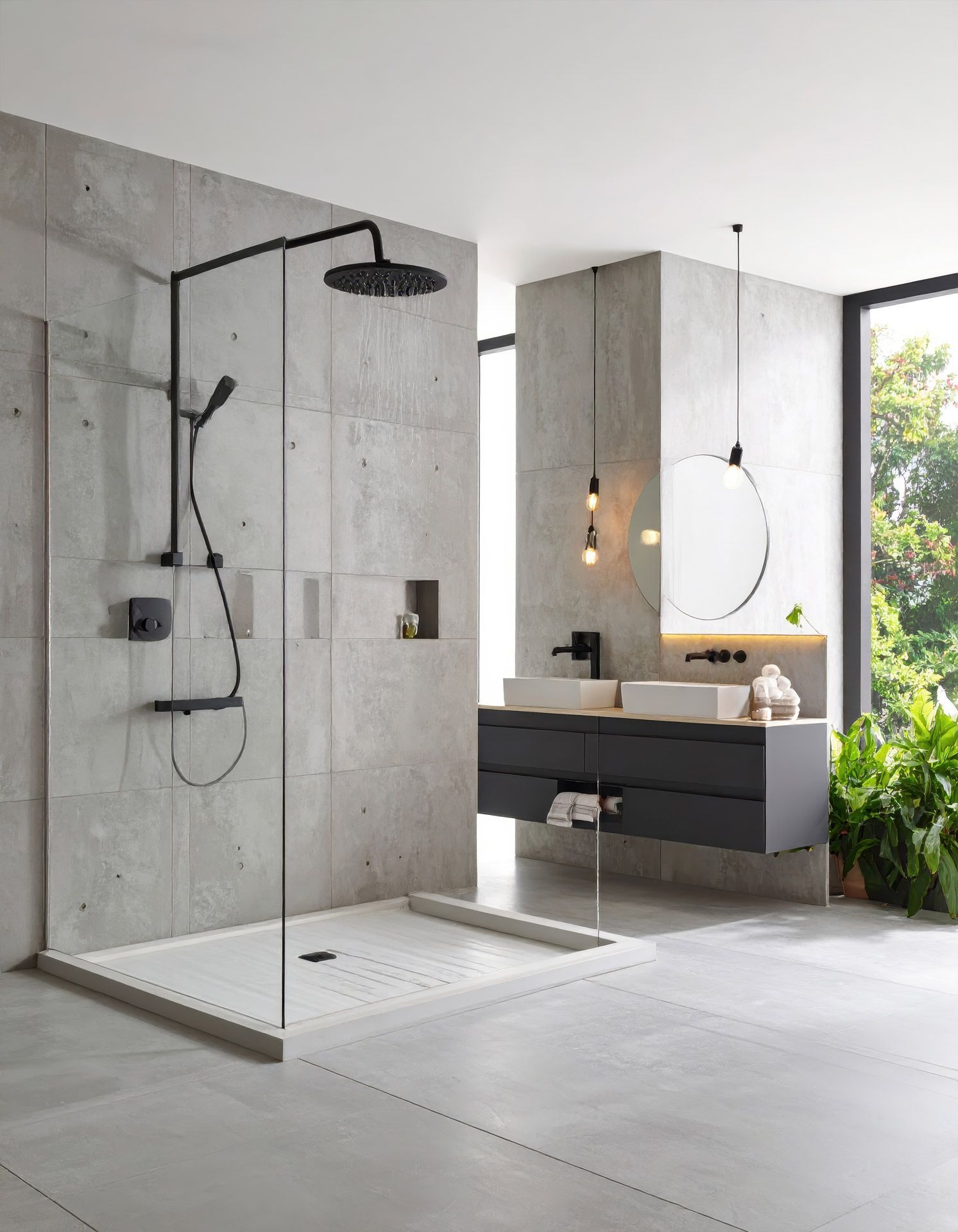 Modern bathroom with walk-in shower, double vanity, round mirror, and floor-to-ceiling windows overlooking greenery