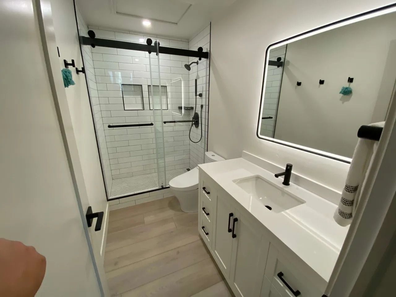 Modern bathroom with glass shower, white vanity, and large mirror