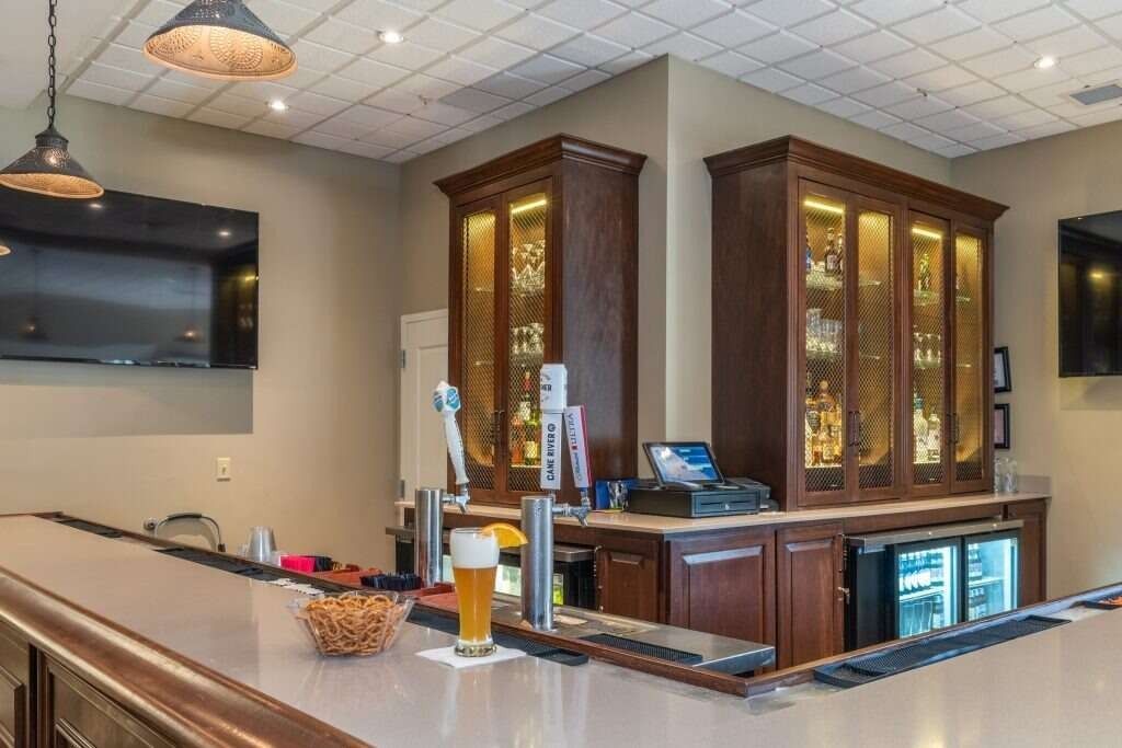 Bar with beer taps, lit display cabinets, and a glass of beer on the counter.