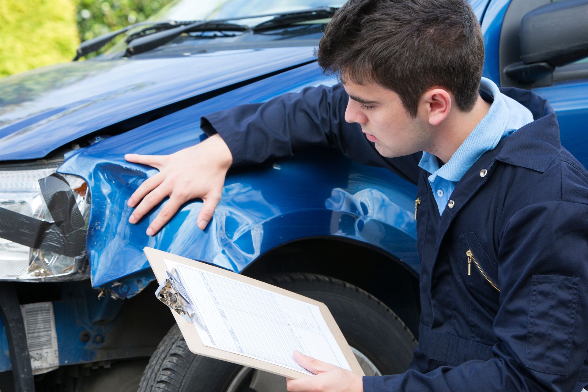 Auto workshop mechanic inspecting damage