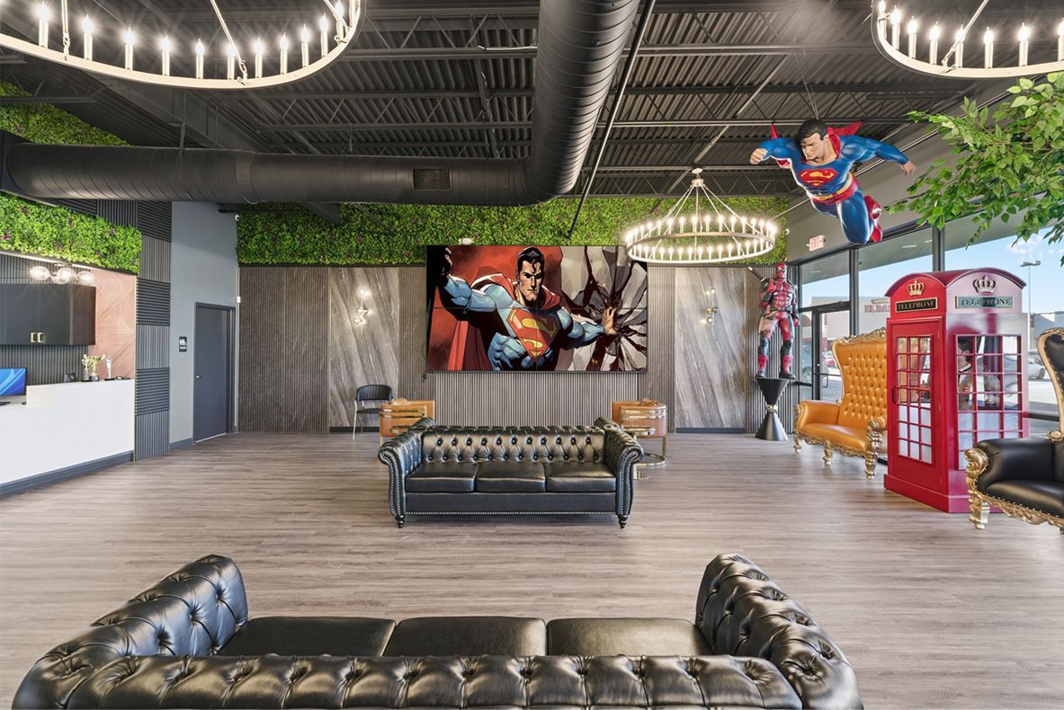 Lobby with black leather sofas, superhero decor, a large screen, and decorative light fixtures. Adventure Smiles Dental and Orthodontics -Pasadena