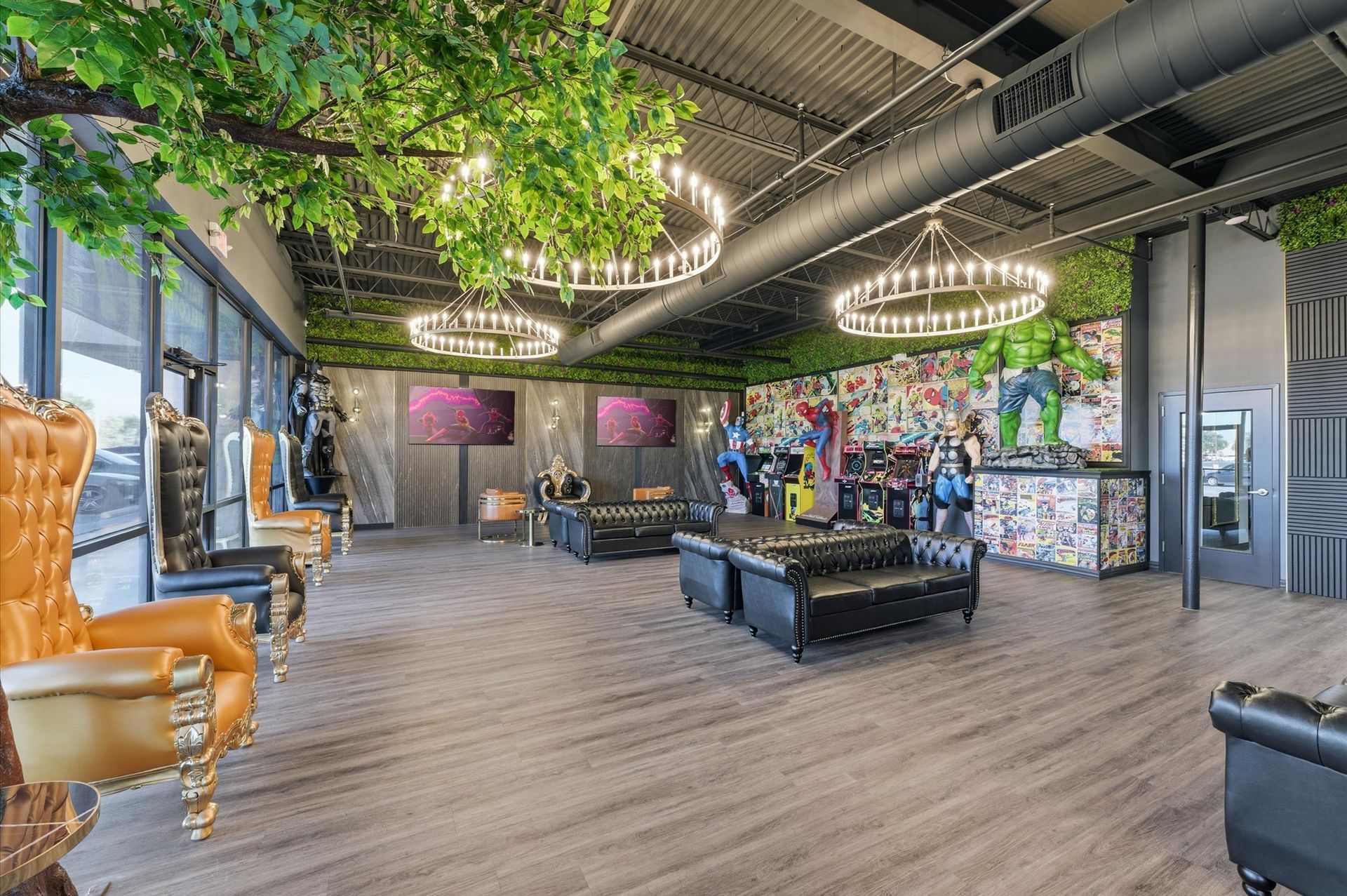 Lounge area with ornate chairs, black leather furniture, and a colorful mural. Greenery and chandeliers hang from the ceiling. Adventure Smiles Dental and Orthodontics -Pasadena