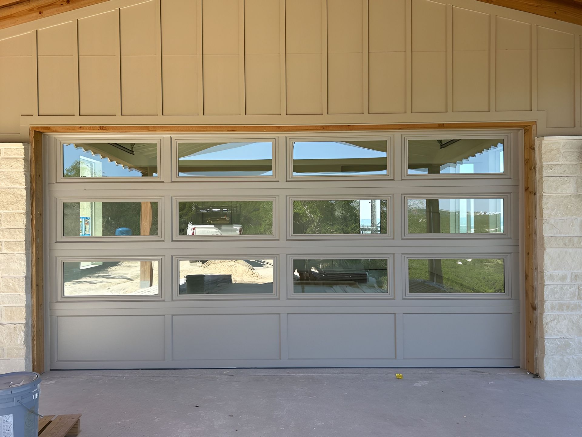 Tan garage door with multiple window panes on a house exterior