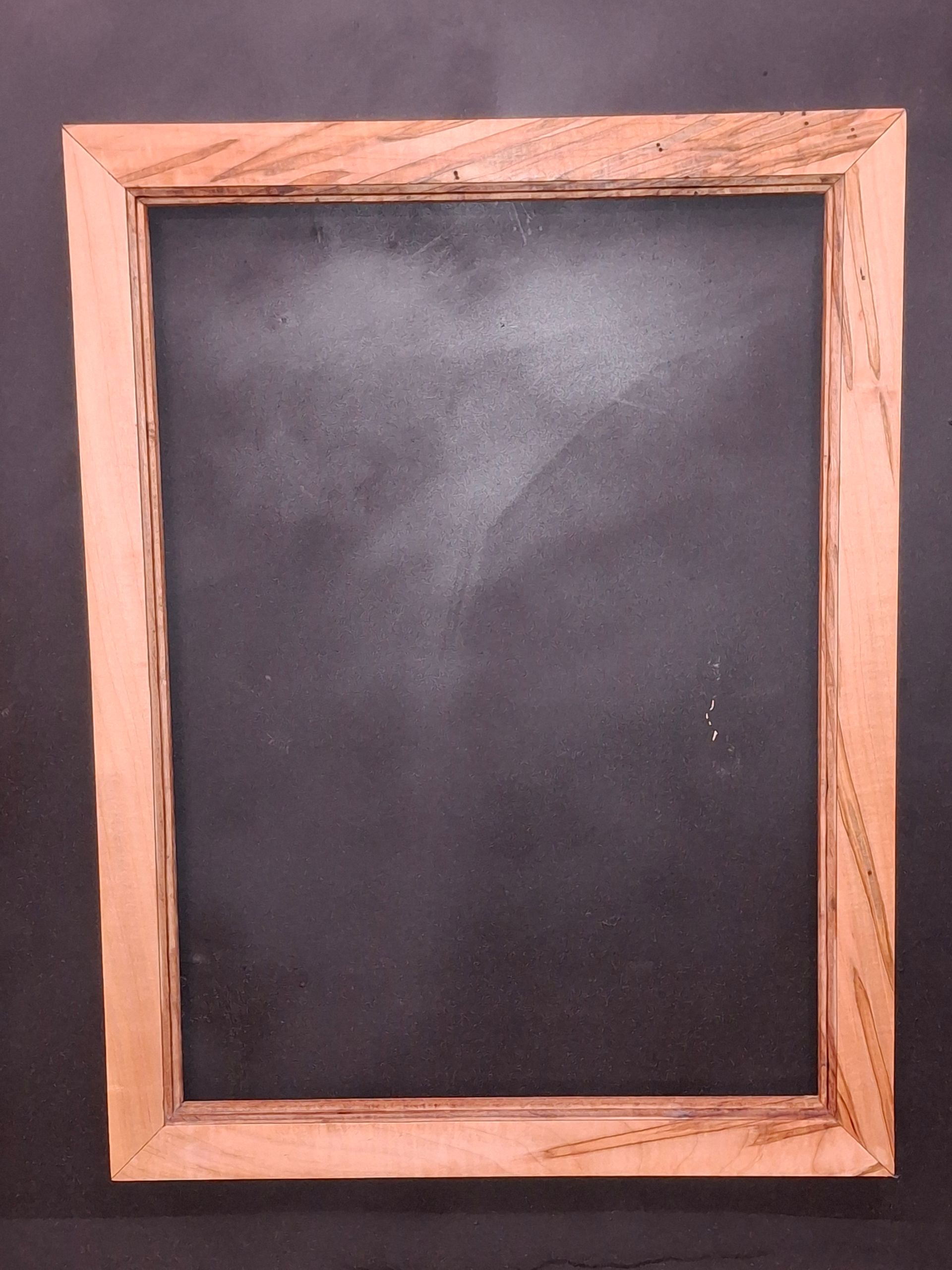 A vertical, rectangular chalkboard with a light-colored wooden frame, set against a dark background.