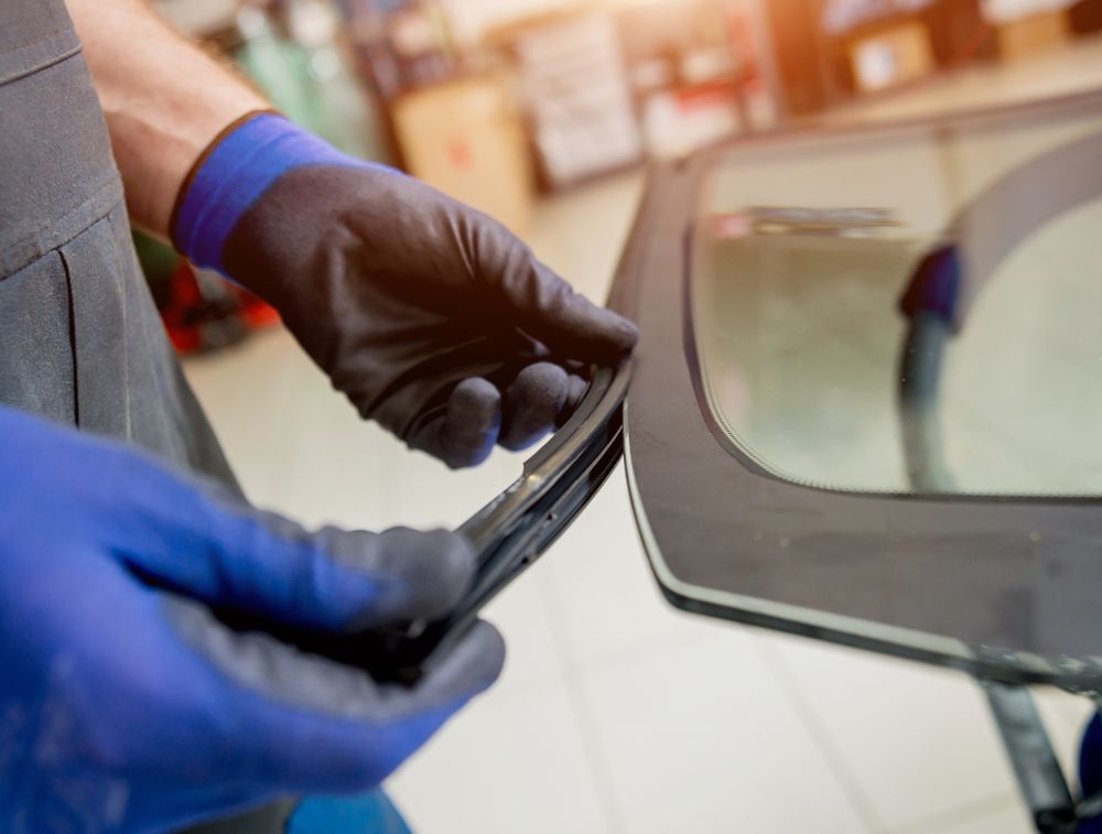 A Man is Installing a Windshield on a Car — Crakka Windscreens in Diamond Beach, NSW