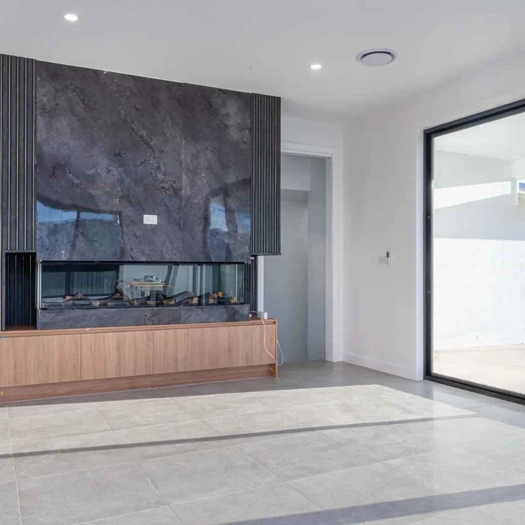 A Living Room With A Fireplace And A Large Window — ASM Joinery In Fyshwick, ACT