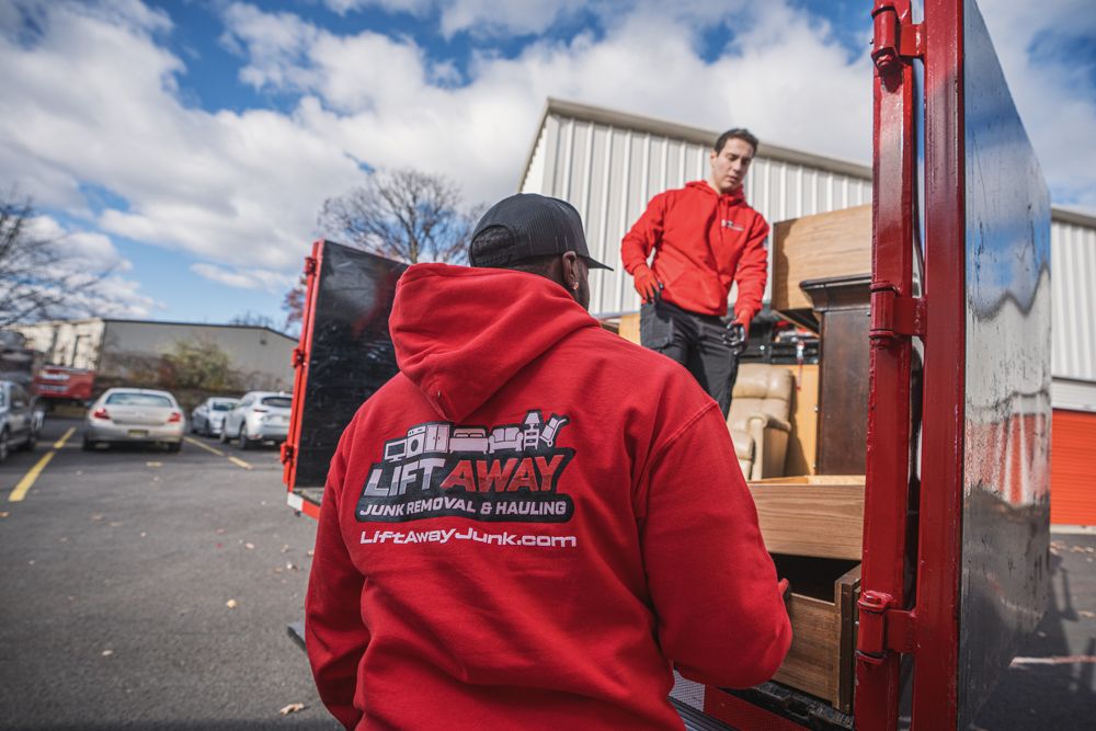 Two men loading furniture into a red truck, one wearing a 