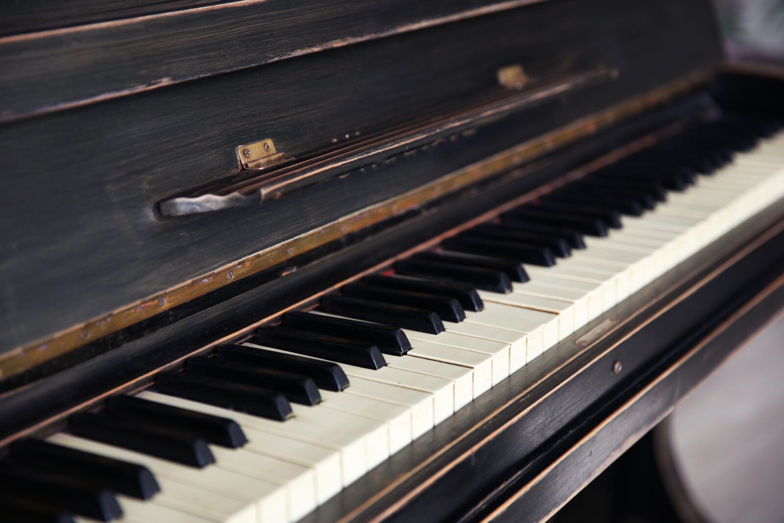 Black piano with white and black keys, close-up view.