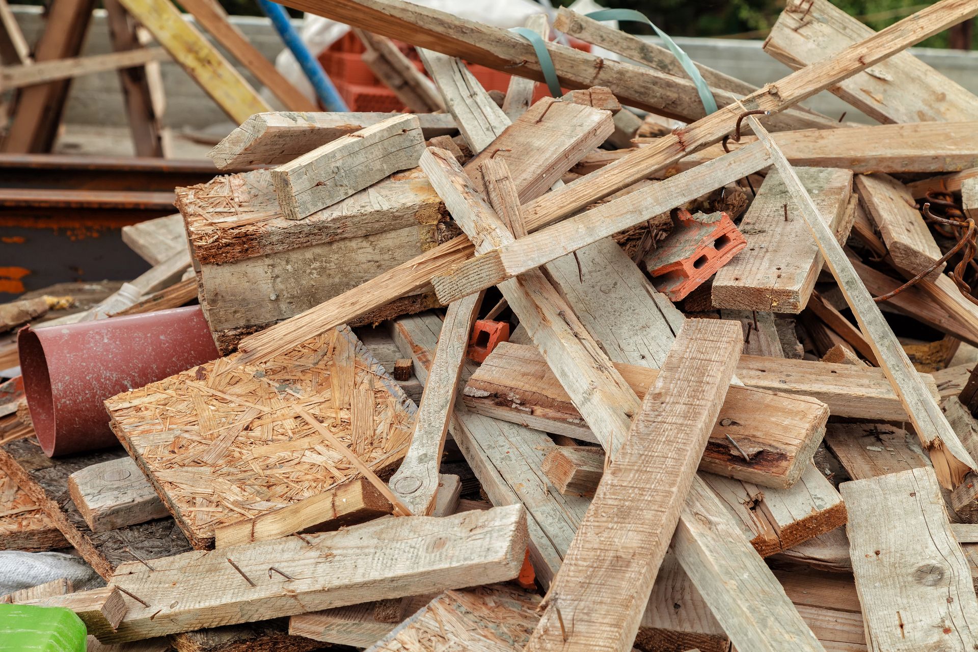 Pile of assorted wood scraps and debris outdoors.