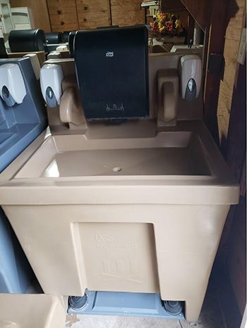 A bathroom sink with a paper towel dispenser and a mirror.