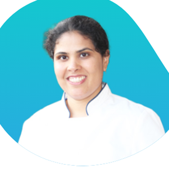 Smiling person in a white coat against a bright blue background Smiling person in a white coat against a bright blue background