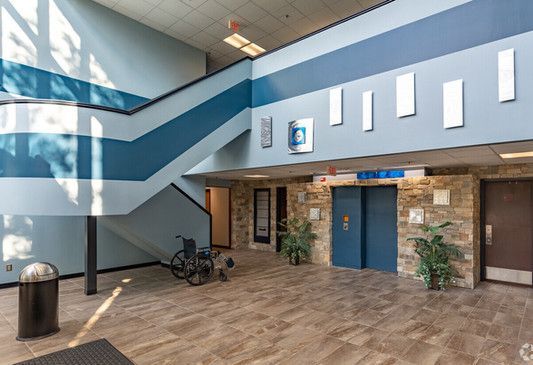 There is a wheelchair in the lobby of a building.